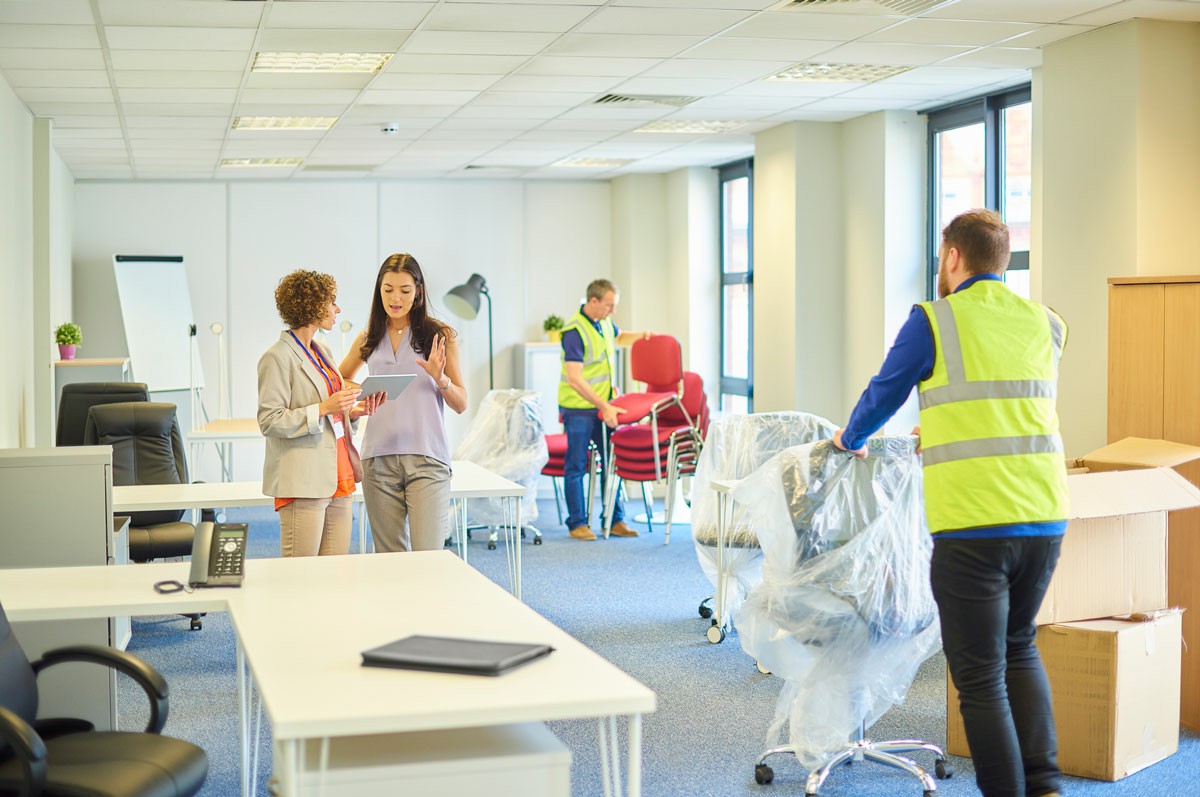 Partner with Trusted Office Movers for a Hassle-Free Relocation Team members in an office setting with boxes, illustrating a hassle-free move facilitated by Trusted Office Movers; Partner with Trusted Office Movers for a Hassle-Free Relocation
